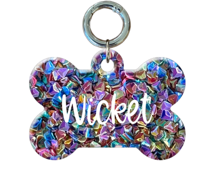 Colorful bone-shaped pet tag with 'Wicket'  on a white background